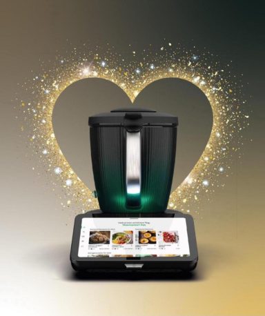 Ein schwarzer Küchenmixer mit glühendem Herz und Rezeptbildern auf dem Bildschirm.